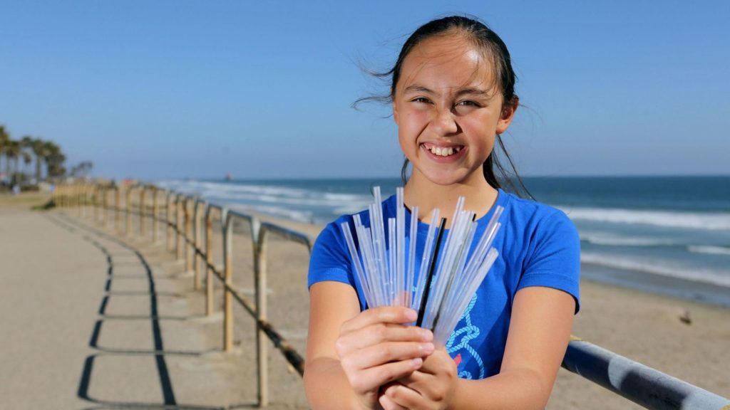 Chloe Mei smiling, straws collected from beach in hand